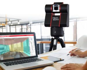 3D-Raumscanner auf Stativ neben Laptop 3D-Laserscanner auf Stativ; daneben ein Laptop mit 3D-Ansicht, im Vordergrund schreibt eine Person auf Papier.