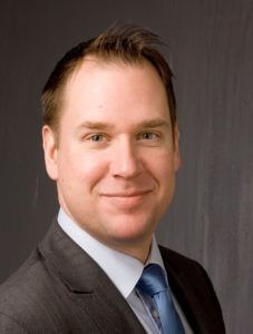 Porträt Roland Riethmüller, Vorstand Bundesverband Digitales Bauwesen Roland Riethmüller, Vorstand Bundesverband Digitales Bauwesen, im Anzug vor neutralem Hintergrund.